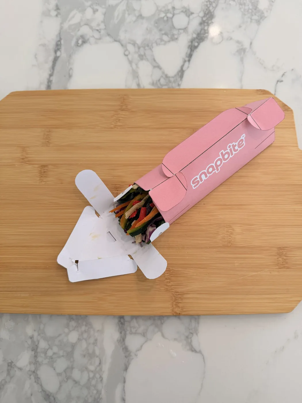 The SnapBite prototype sliding out of its pink sleeve