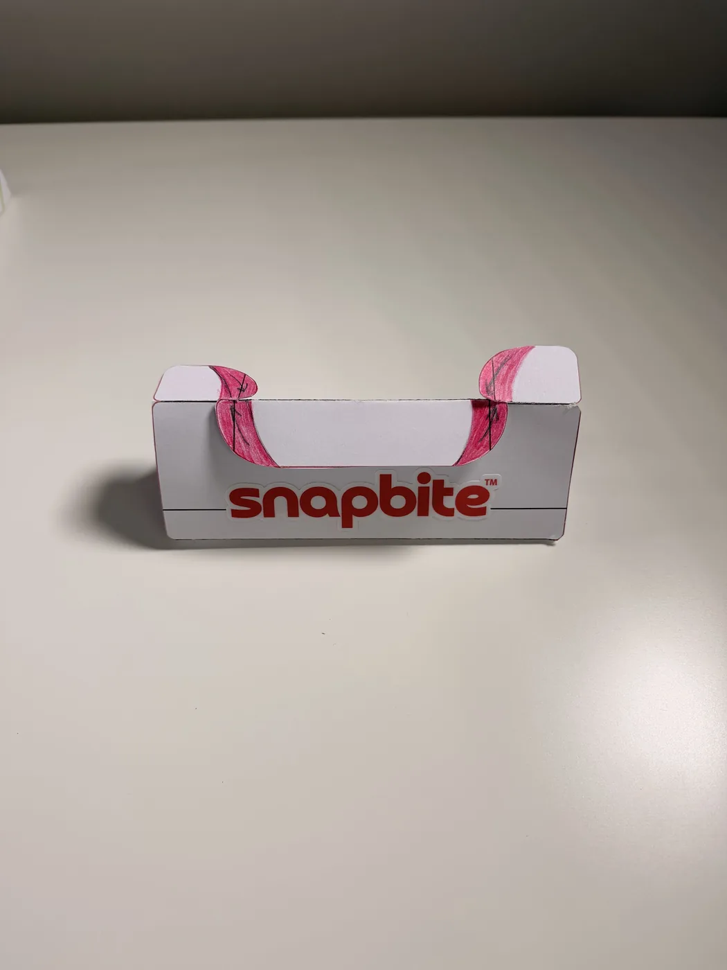An early white SnapBite box prototype with pink tabs