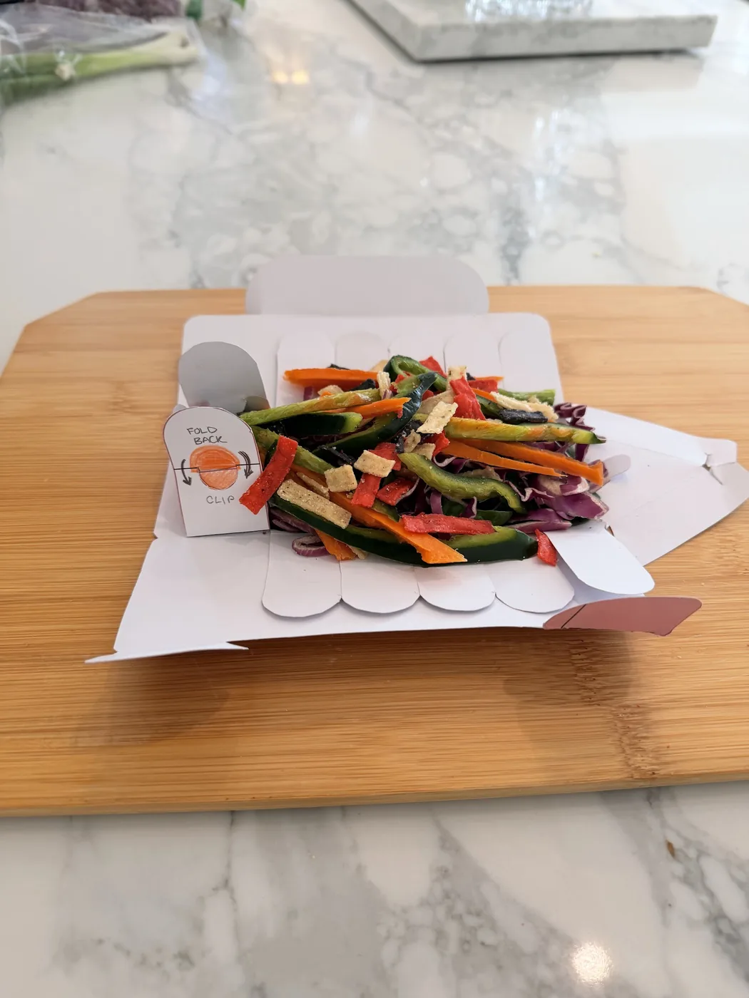 The tray opened with shredded vegetables and a fold back and clip tab